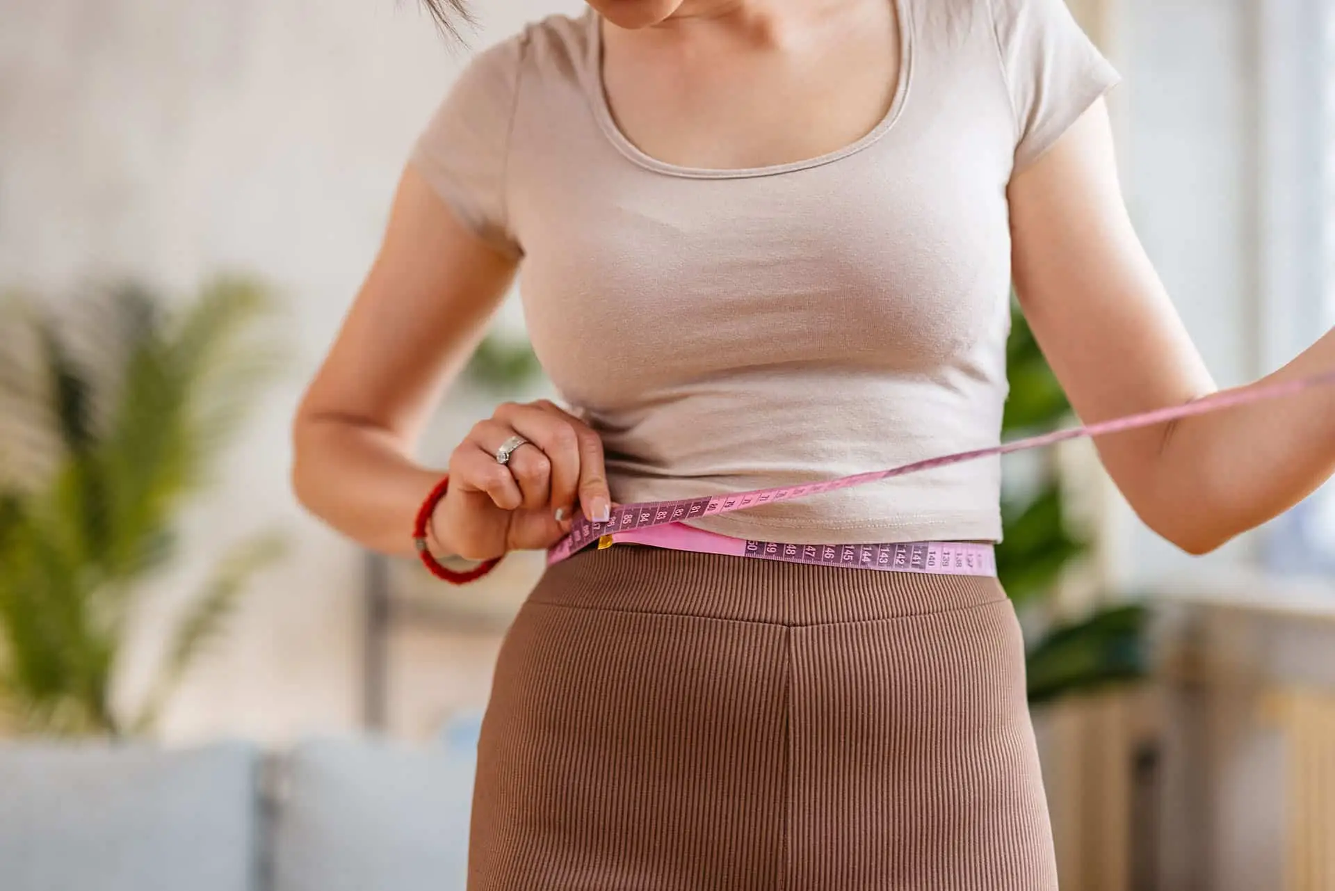 A woman measuring her waist